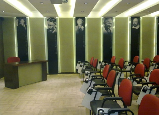 Renovated seminar hall at IGIDR with portrait panels and red chairs