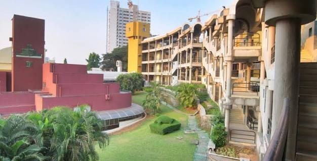 IGIDR campus courtyard with terraced residential blocks and the red brick library